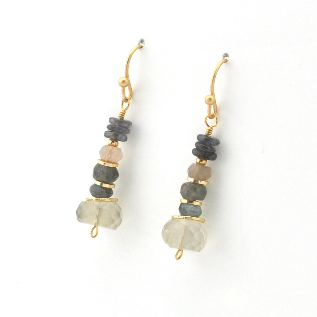 A pair of gold-tone dangle earrings with stacked natural stones in gray, pale pink, and frosted white, shown on a plain white background.
