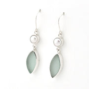 A pair of silver dangle earrings featuring a small white pearl and a larger teardrop-shaped light green stone in a silver bezel setting, shown against a plain white background.