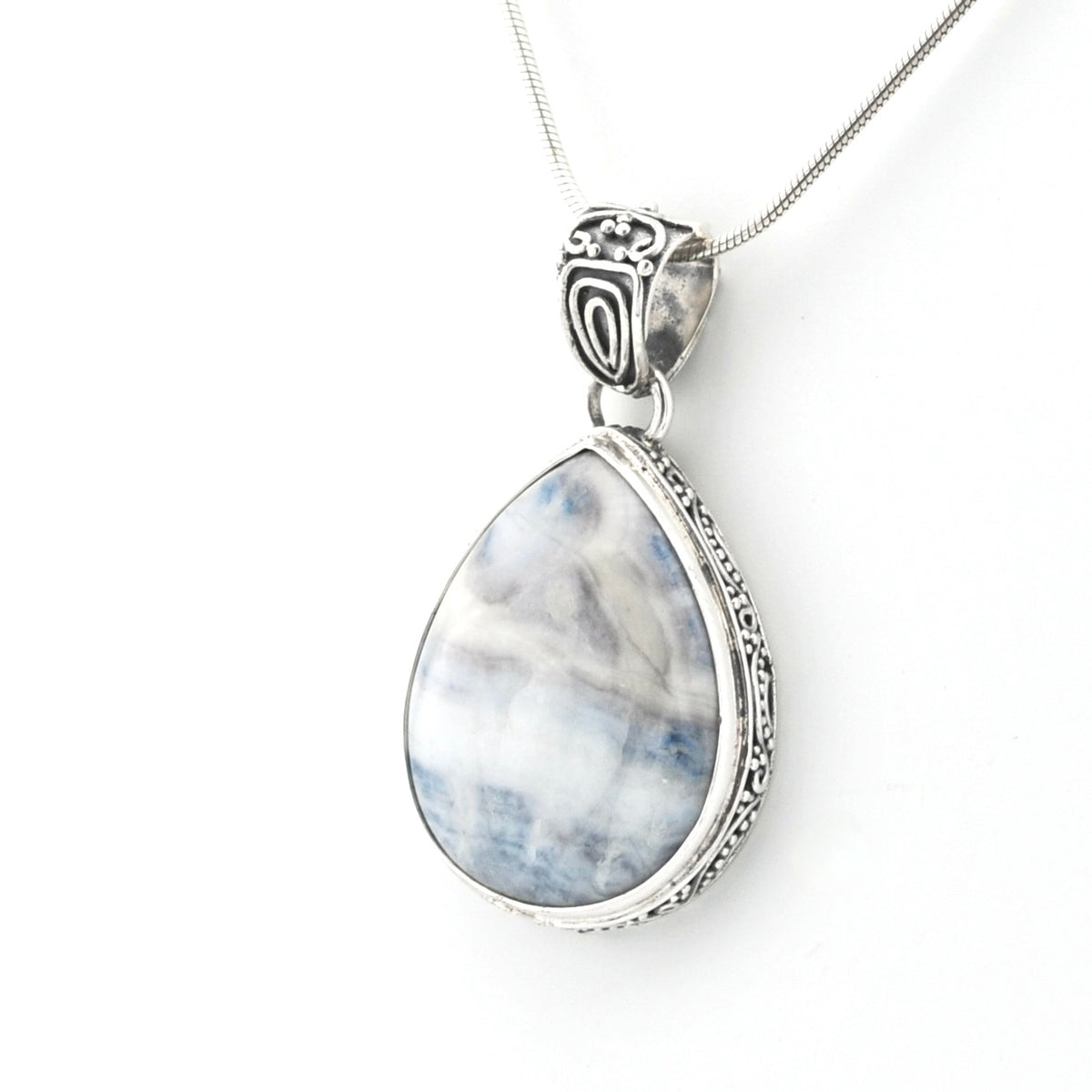 A silver teardrop pendant necklace featuring a marbled blue and white stone, suspended from a delicate silver chain against a plain white background.