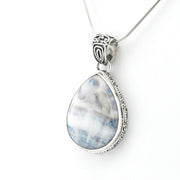 A silver teardrop pendant necklace featuring a marbled blue and white stone, suspended from a delicate silver chain against a plain white background.