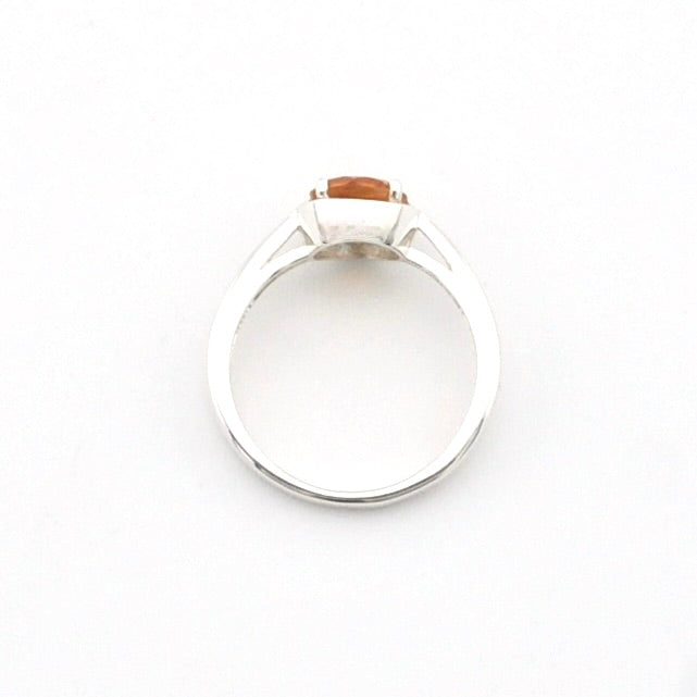 A silver ring with a small rectangular orange gemstone, photographed from above on a plain white background.