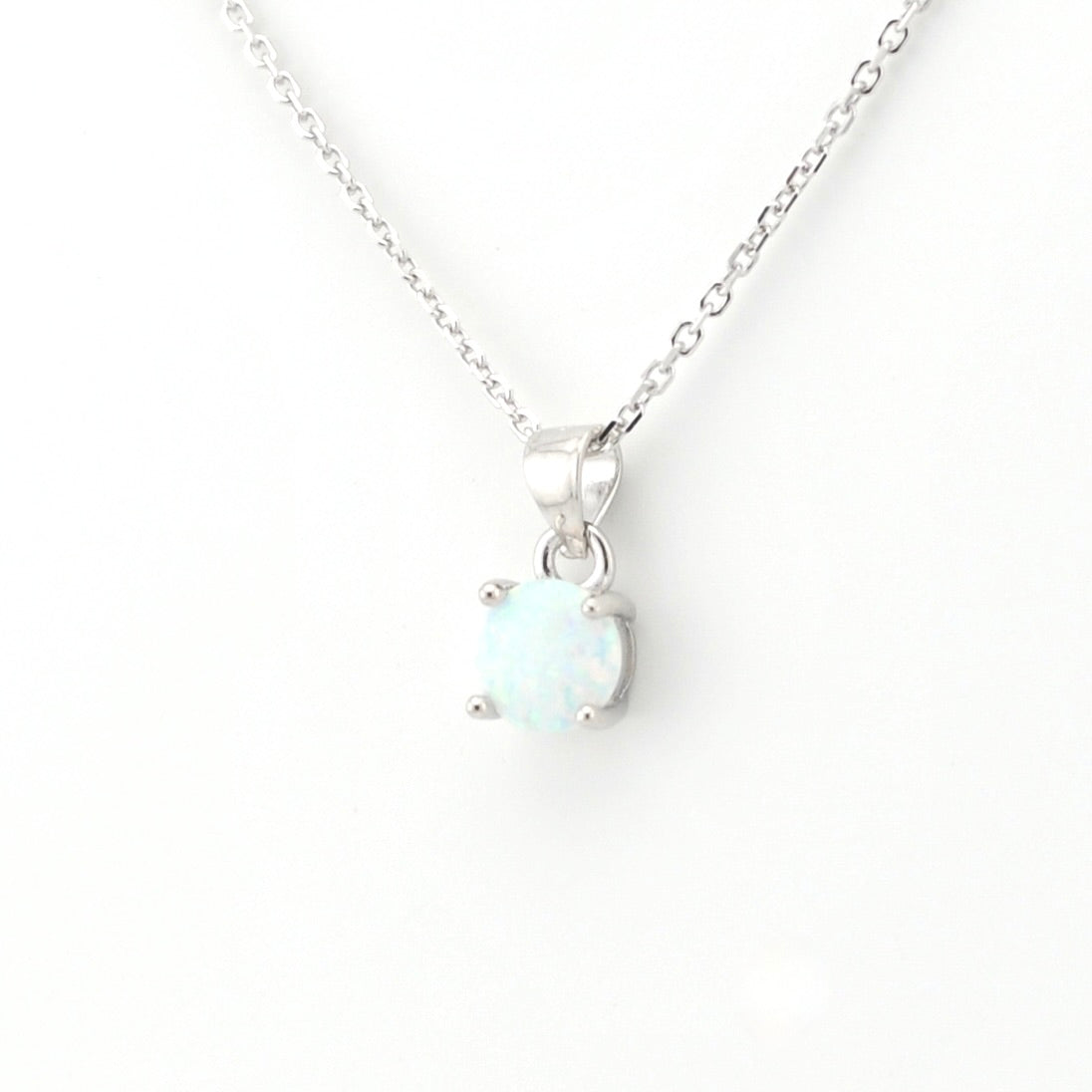 A silver necklace with a round bezel-set white opal pendant, displayed against a clean white background.
