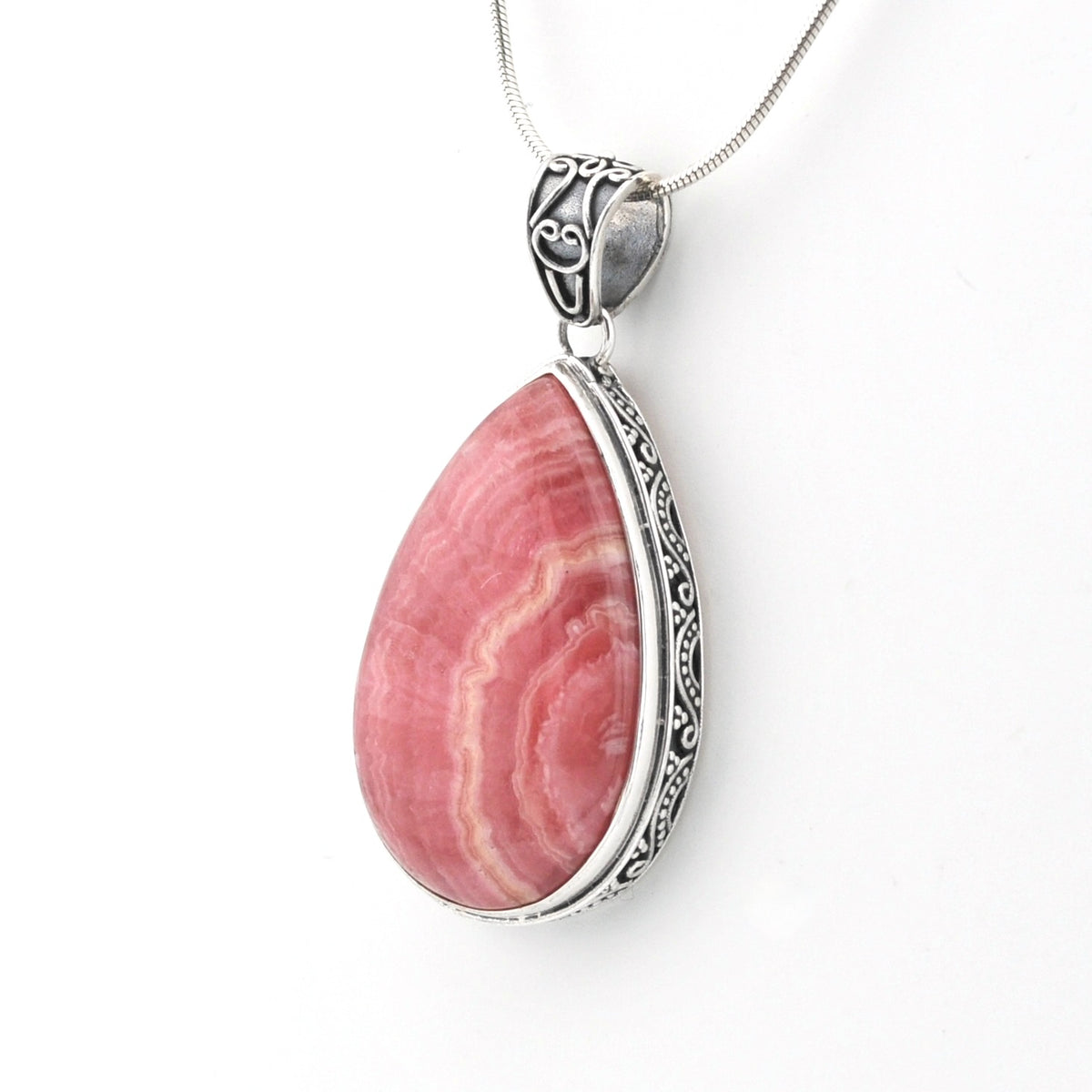 A teardrop-shaped pink stone pendant necklace with a silver-toned ornate bezel and chain, shown on a plain white background.