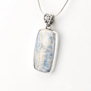A silver-toned rectangular pendant necklace featuring a polished light blue and white marbled stone, suspended from a delicate silver chain against a plain white background.