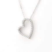 A silver heart-shaped pendant necklace with a delicate chain, featuring a border of small clear stones, shown against a plain white background.