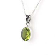 An oval green gemstone pendant necklace set in a silver bezel with a silver chain, shown against a plain white background.