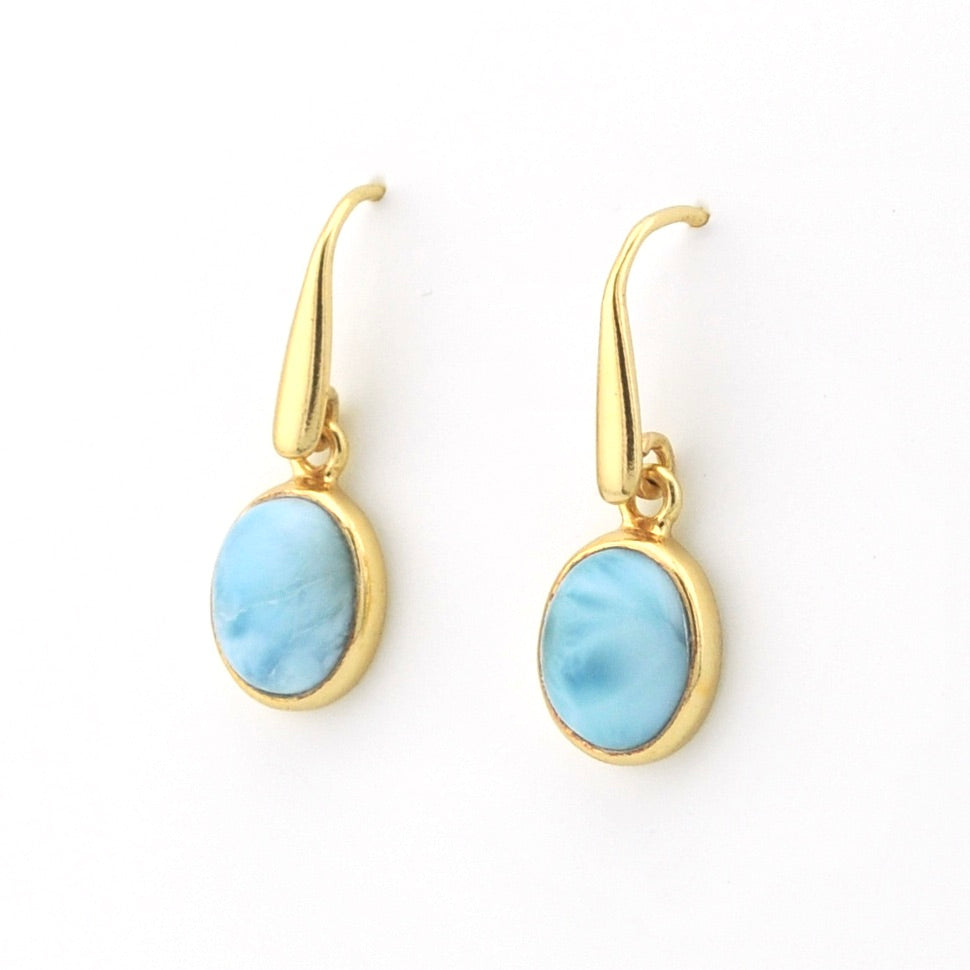 A pair of gold drop earrings with oval light blue marbled stone pendants, shown on a plain white background.