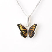 Amber butterfly pendant on silver chain on a white background