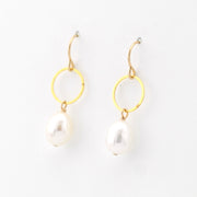 Gold hoop earrings with pearl drops on a white background