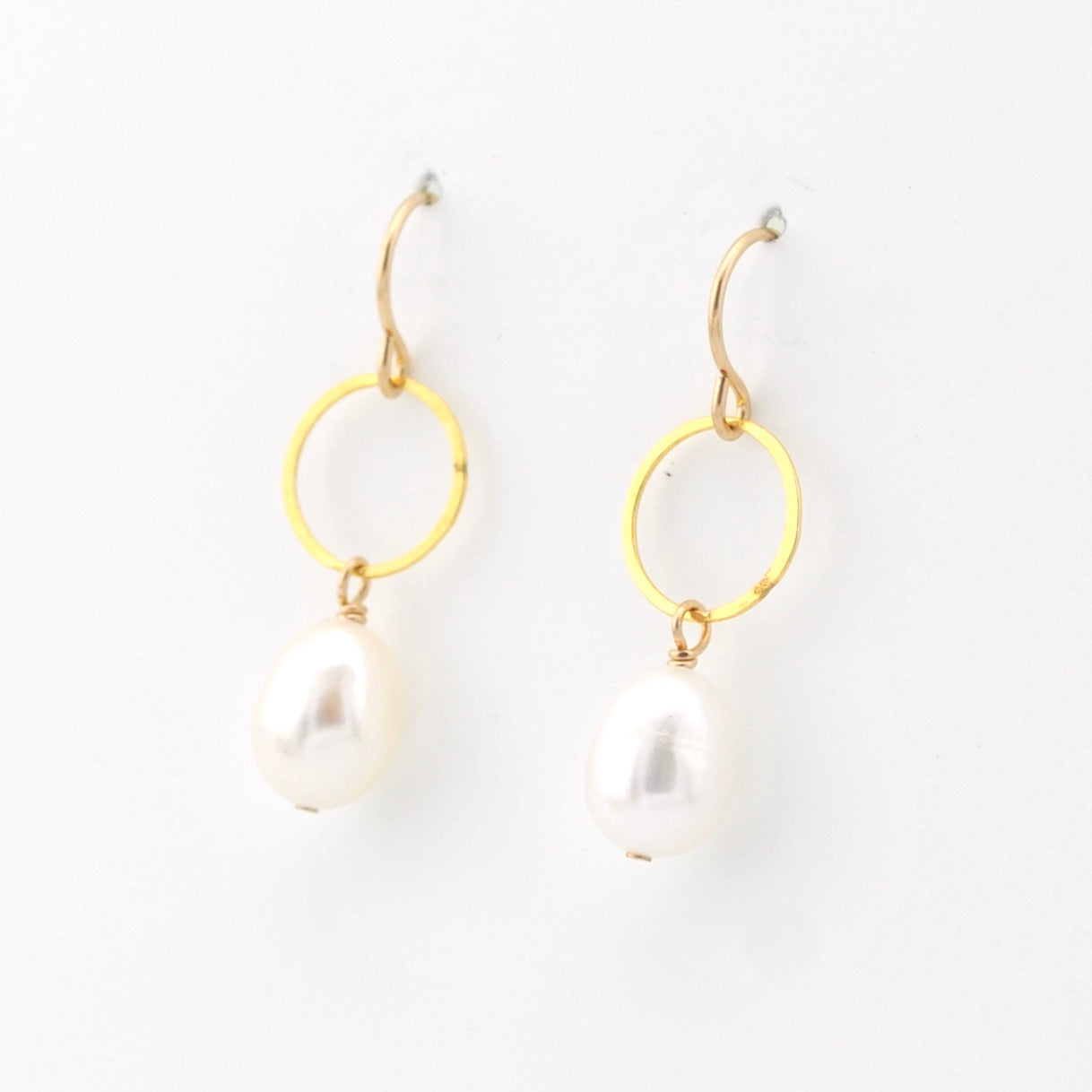 Gold hoop earrings with pearl drops on a white background