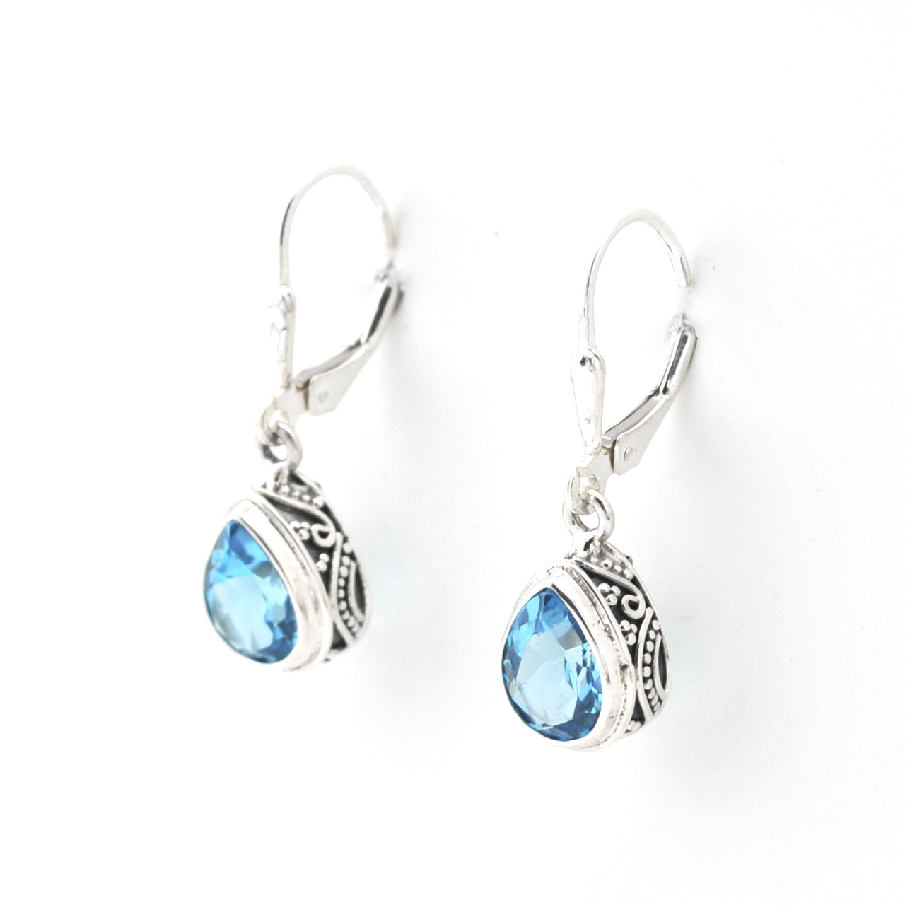 Silver earrings with blue gemstones on a white background