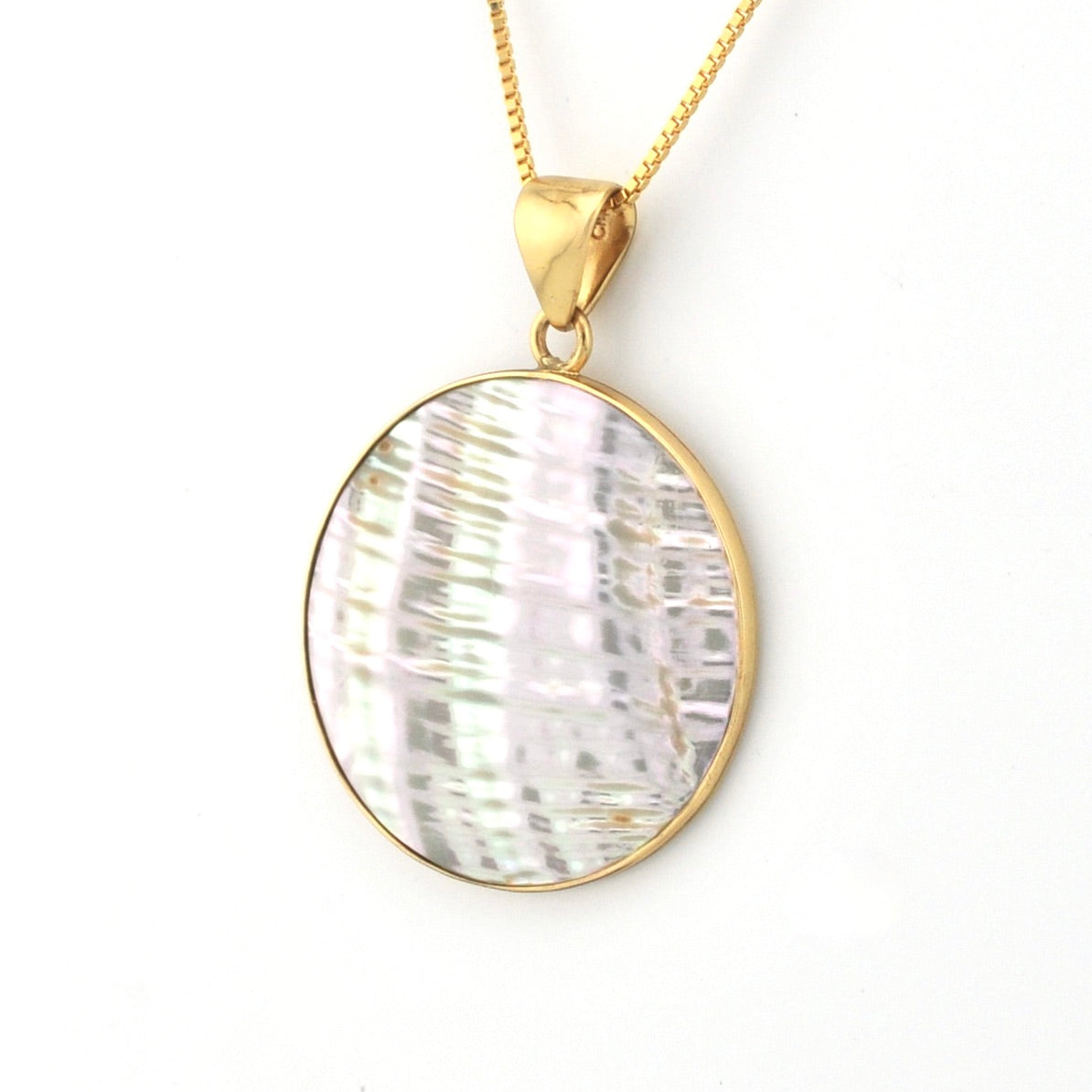 Gold necklace with a round, textured pendant on a white background