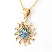 Gold sun-shaped pendant with a colorful center on a white background