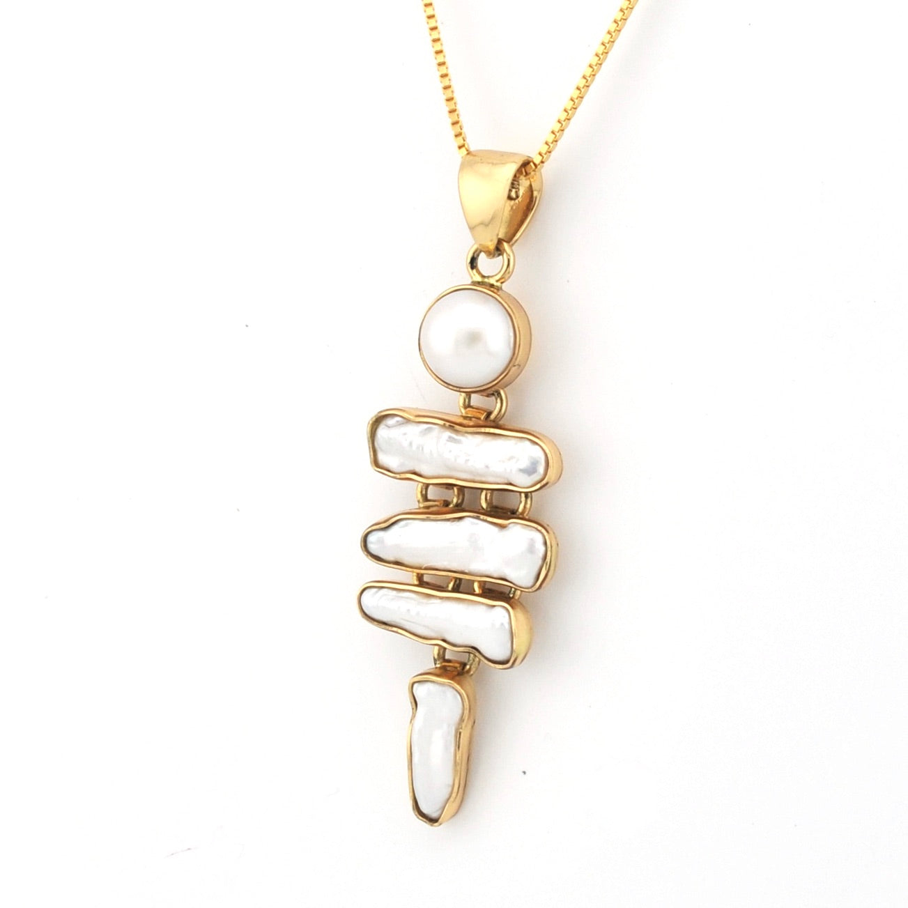 Gold necklace with a pendant featuring stacked white stones on a white background