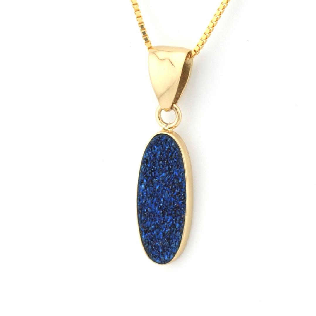 Gold necklace with a blue pendant on a white background