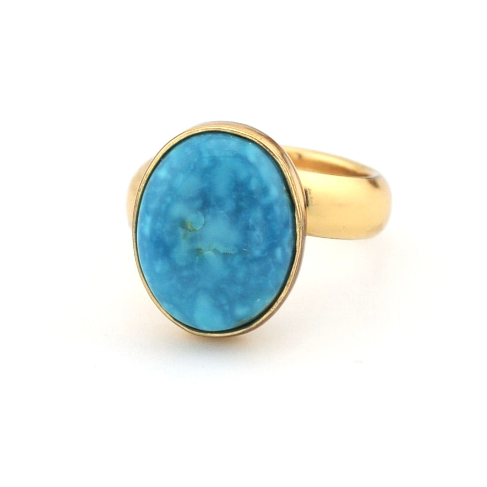 Turquoise and gold ring on white background