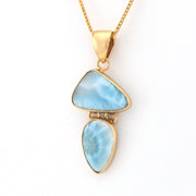 Gold necklace with a blue pendant on a white background