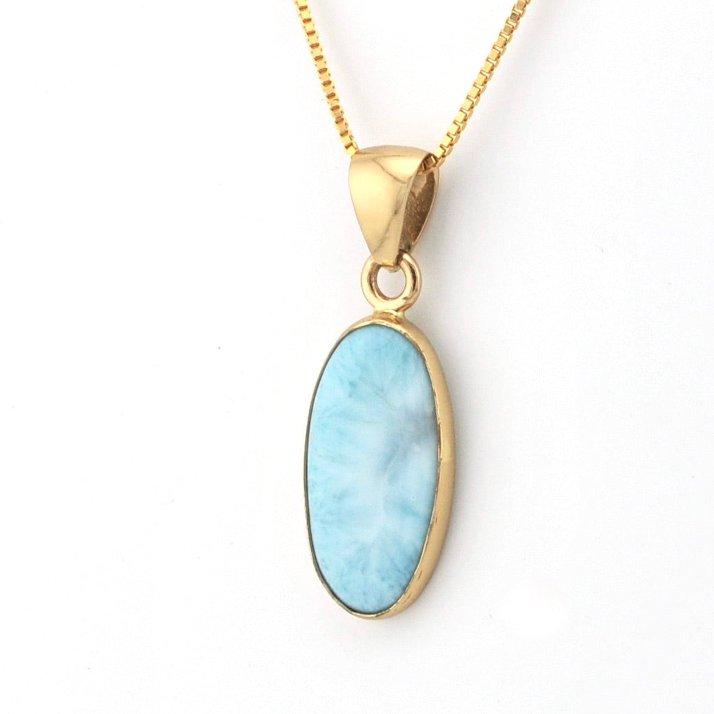 Gold necklace with a blue pendant on a white background