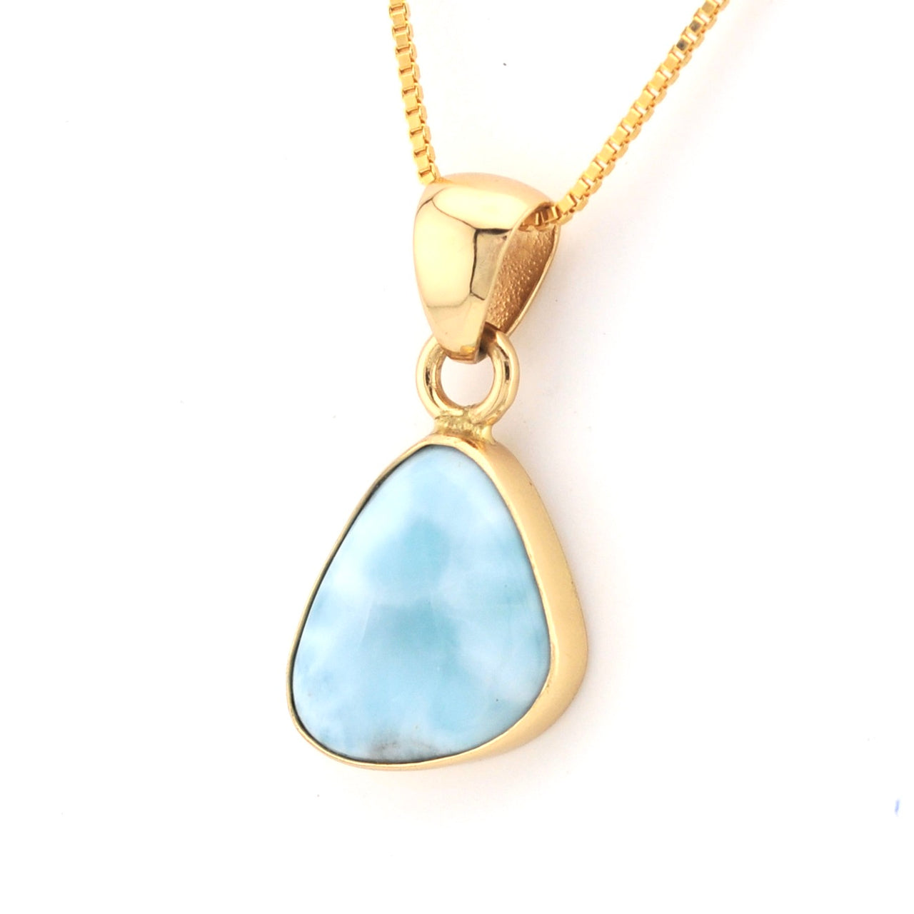 Gold necklace with a blue pendant on a white background