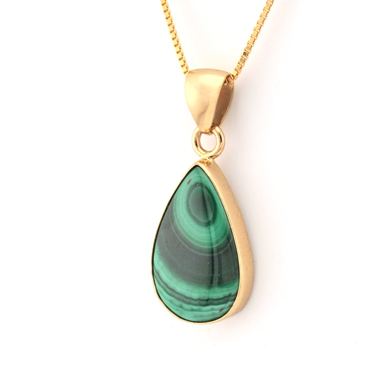 Gold necklace with a green teardrop pendant on a white background