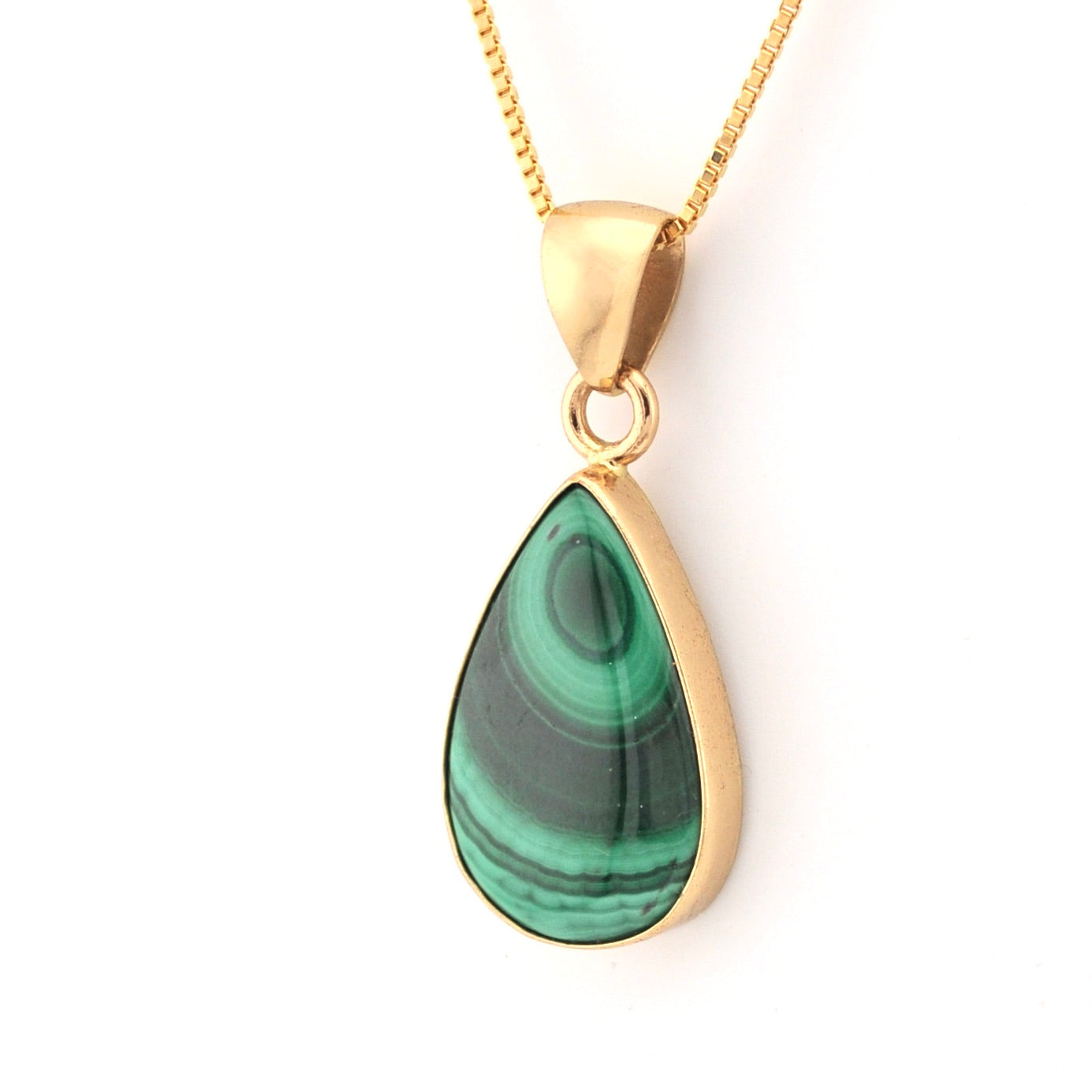 Gold necklace with a green teardrop pendant on a white background