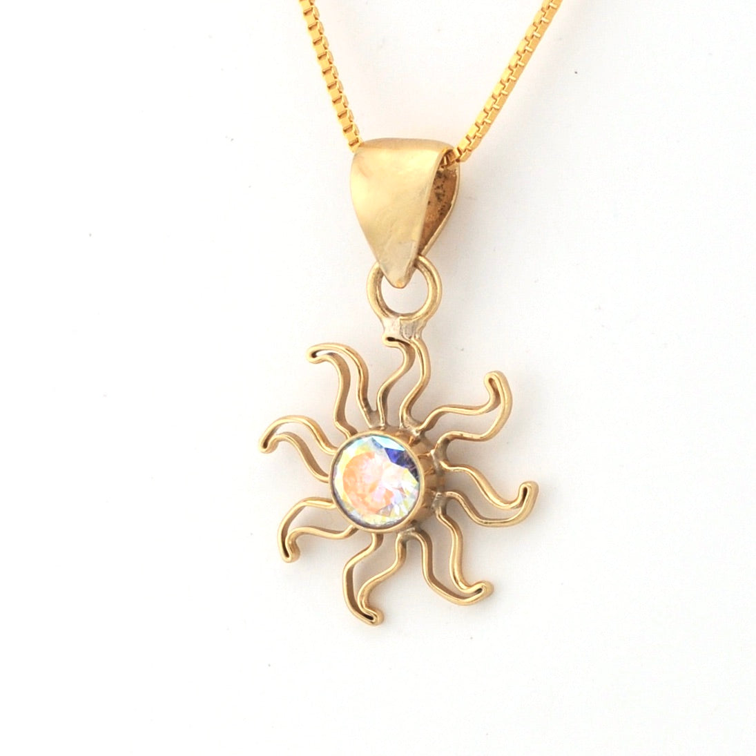 Gold sun-shaped pendant with a colorful center on a white background