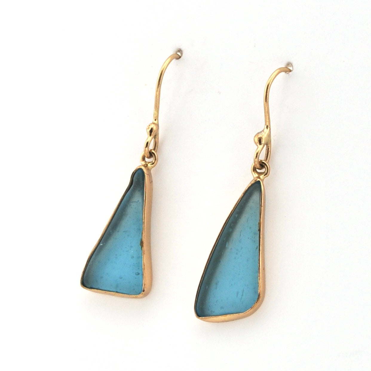 Blue teardrop earrings with gold hooks on a white background