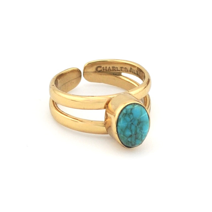 Turquoise and gold ring on white background 