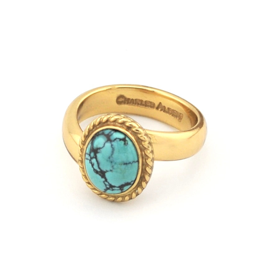 Gold ring with turquoise on white background