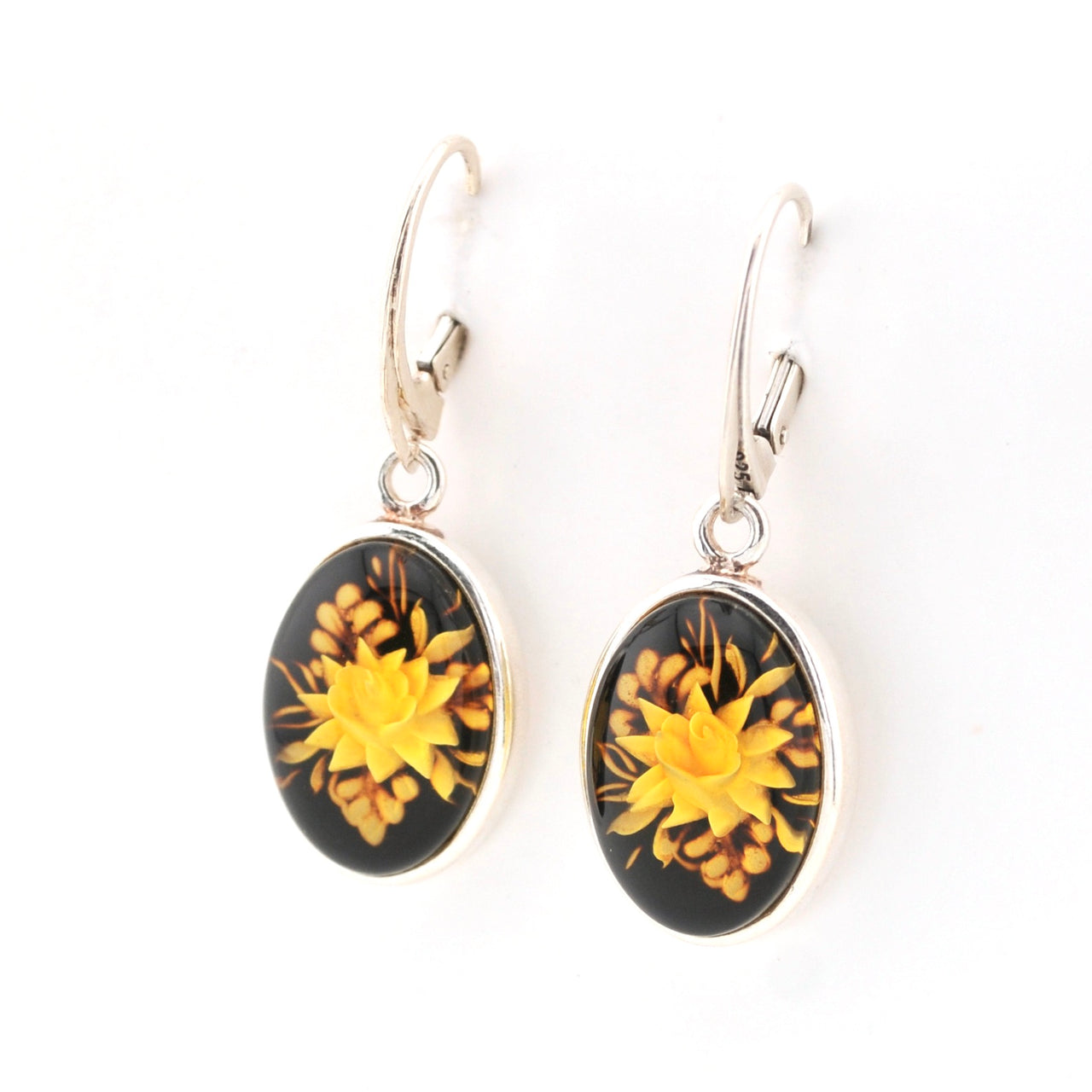 Pair of earrings with yellow floral designs on a white background