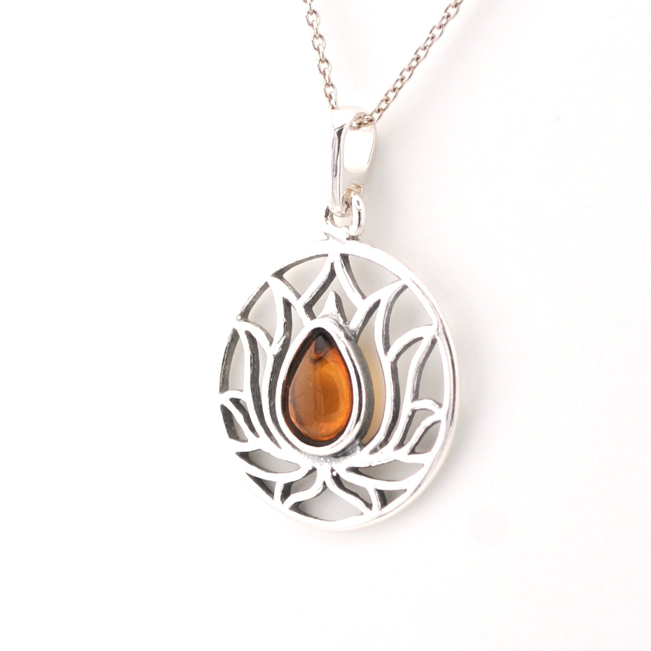 Silver pendant with a teardrop-shaped amber stone on a white background