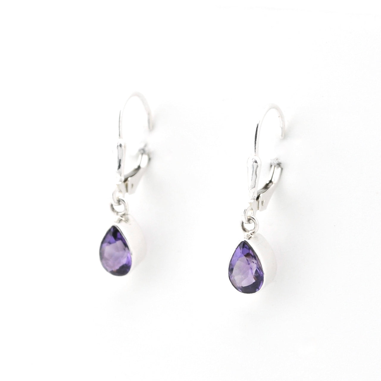 Pair of silver earrings with purple teardrop-shaped gemstones on a white background