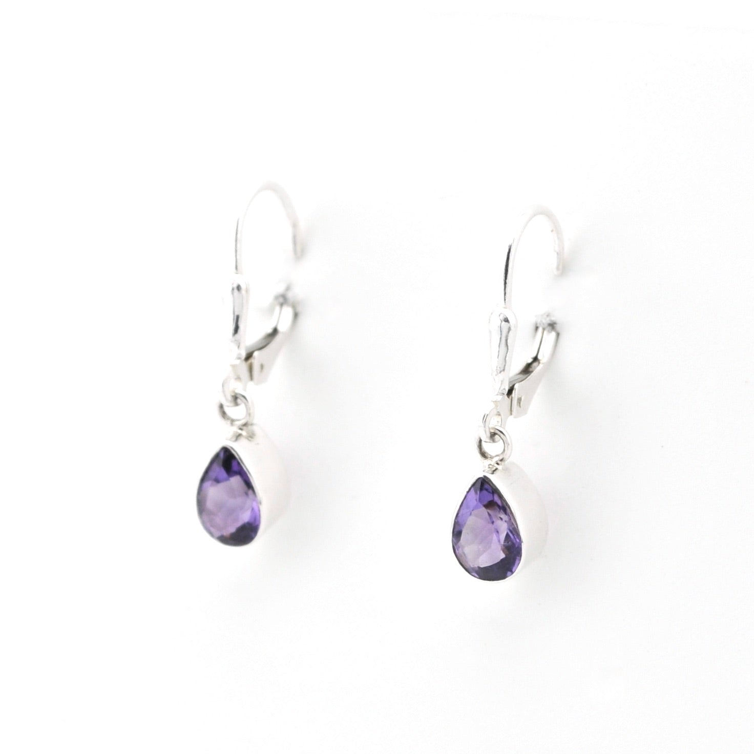Pair of silver earrings with purple teardrop-shaped gemstones on a white background