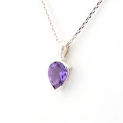 Purple teardrop pendant on a silver chain against a white background