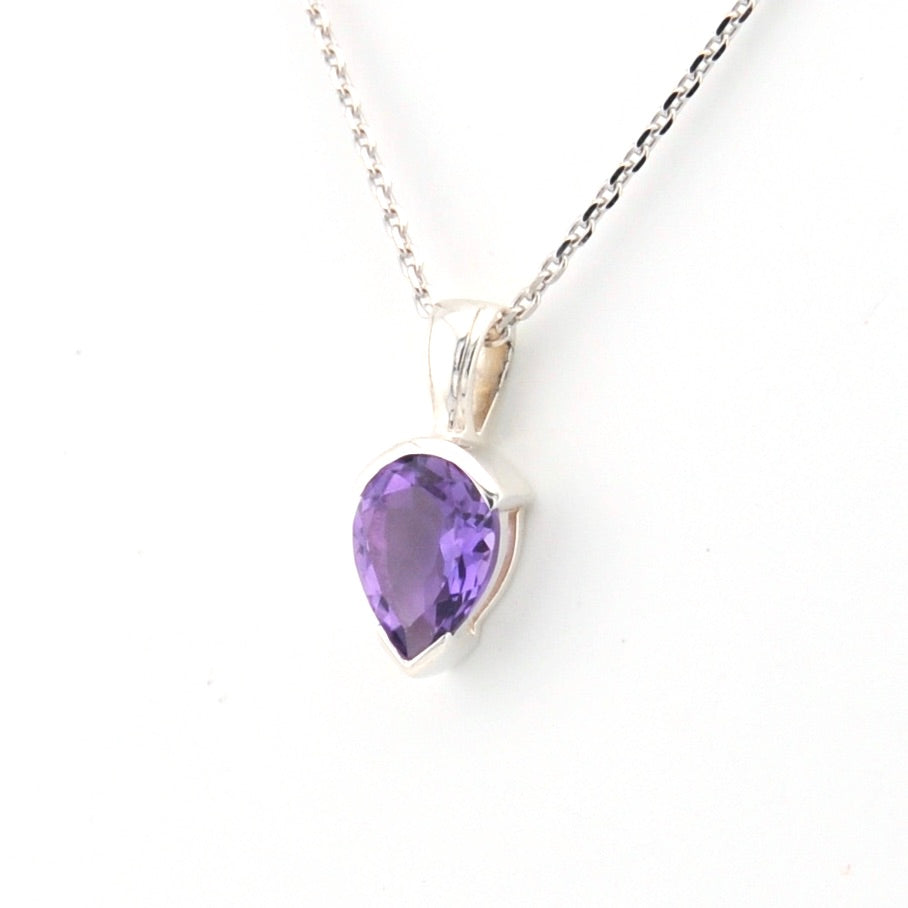 Purple teardrop pendant on a silver chain against a white background