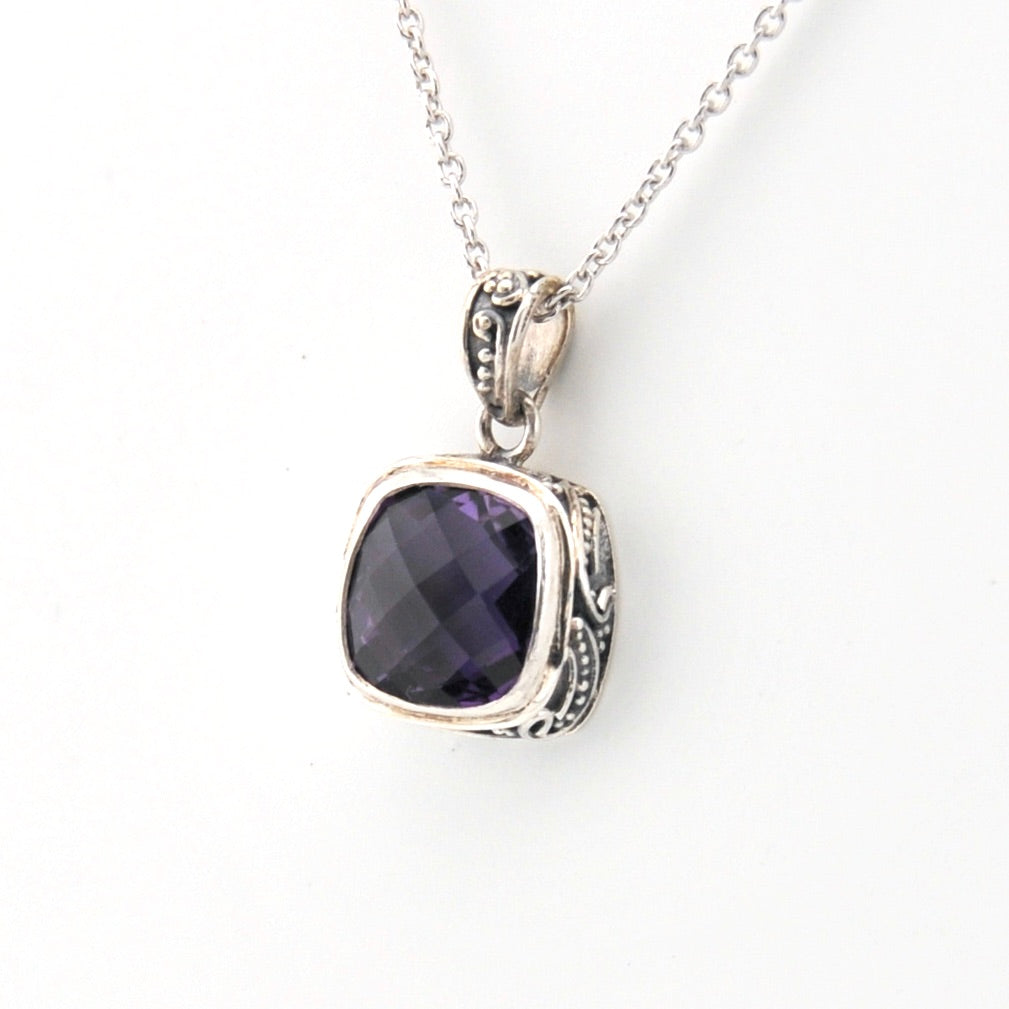 Silver necklace with a purple gemstone pendant on a white background