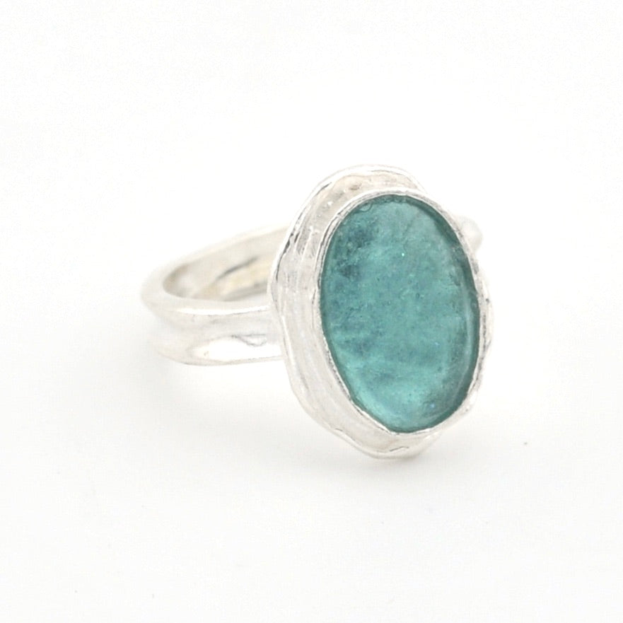 Silver ring with a green Roman glass on a white background