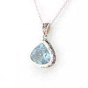 Silver pendant with a blue gemstone on a white background