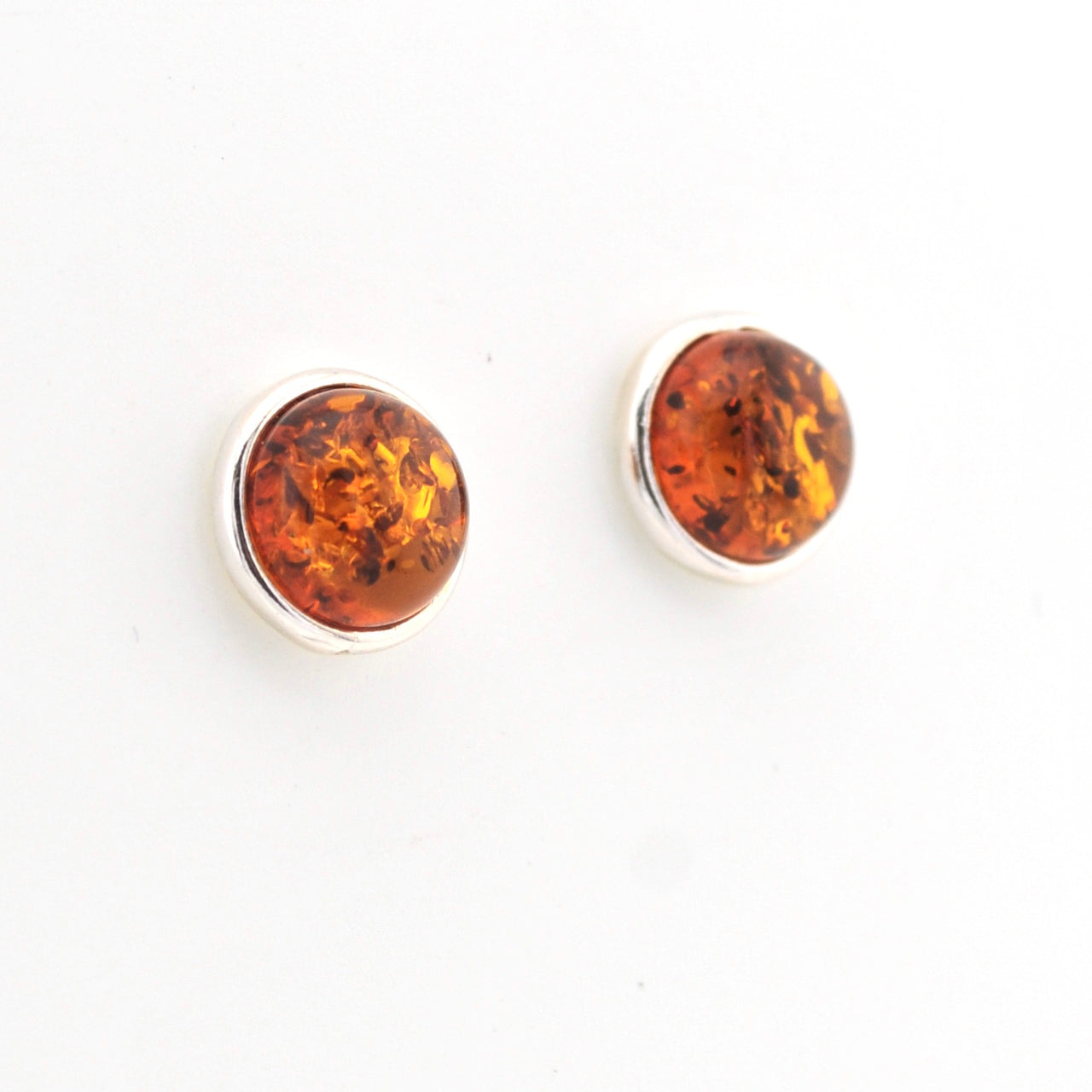 Pair of amber stud earrings on a white background