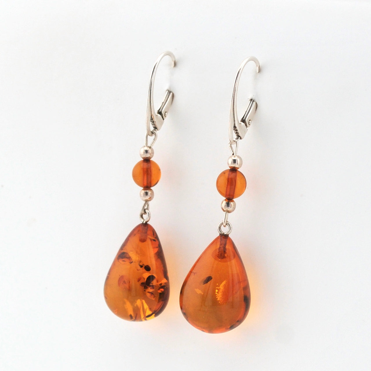 Pair of amber teardrop earrings on a white background