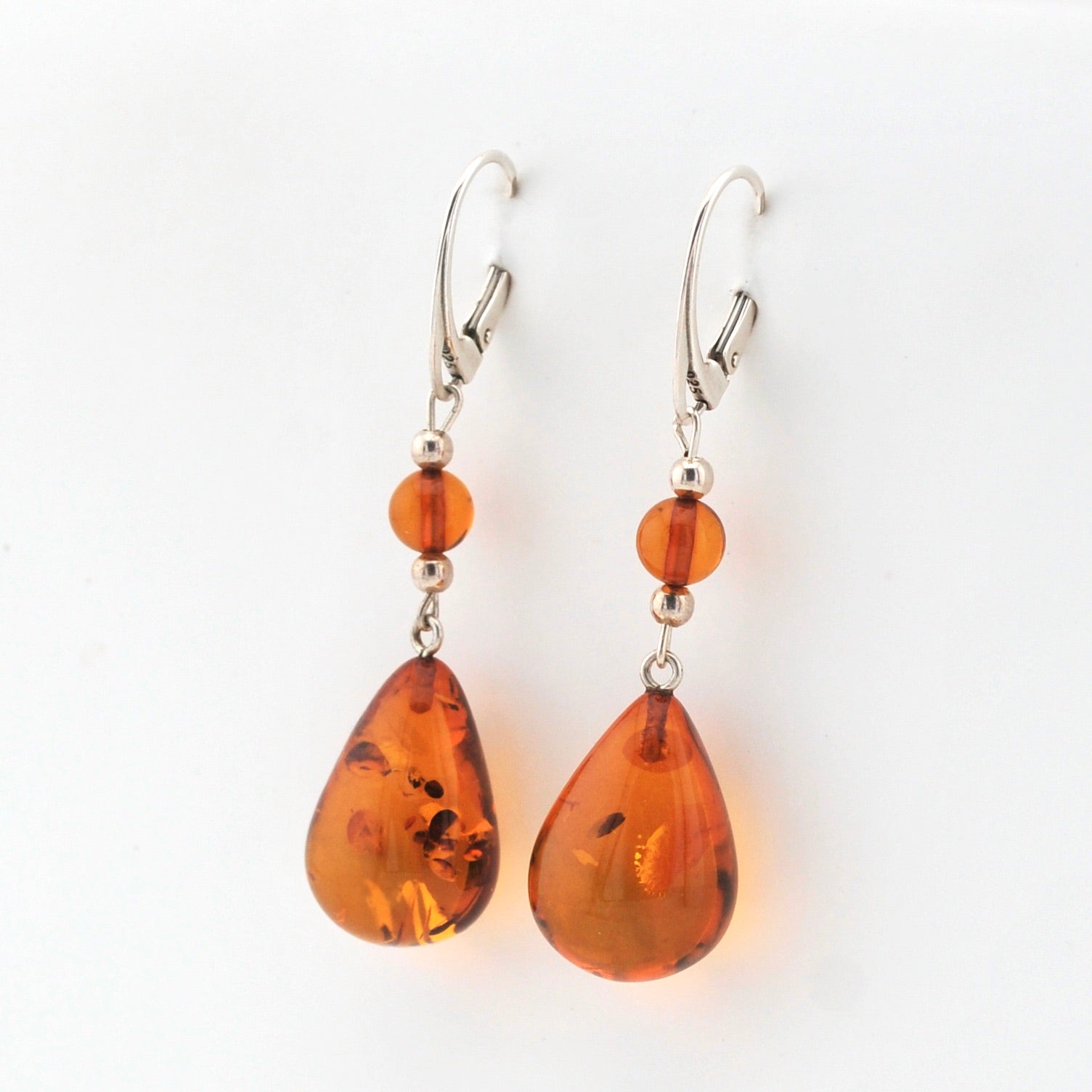 Pair of amber teardrop earrings on a white background