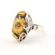 Silver ring with a yellow floral design on a white background