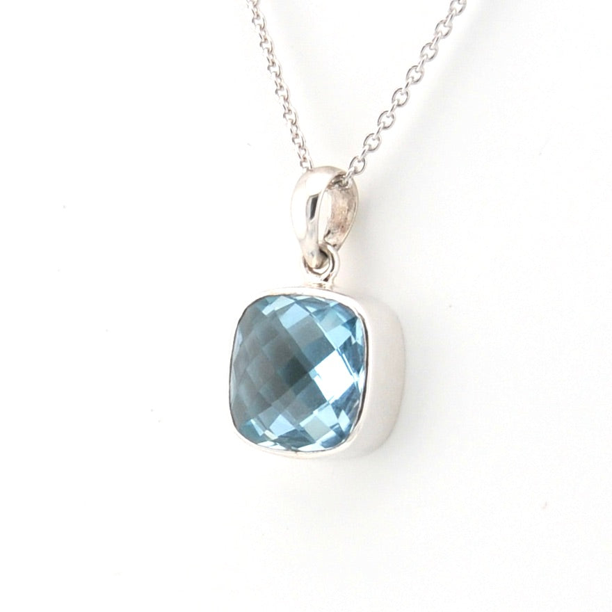 Silver necklace with a blue gemstone pendant on a white background