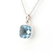 Silver necklace with a blue gemstone pendant on a white background