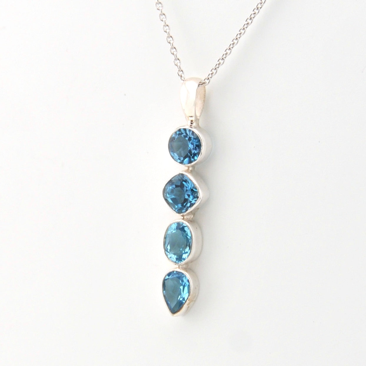 Silver necklace with blue gemstones on a white background