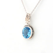Silver necklace with a blue gemstone pendant on a white background