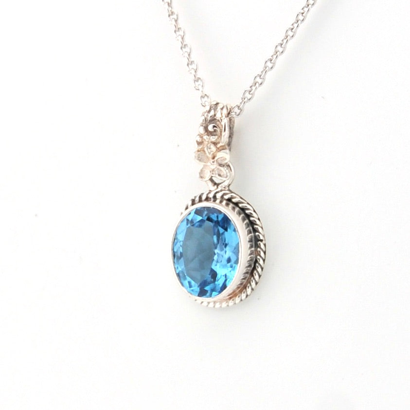 Silver necklace with a blue gemstone pendant on a white background