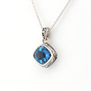 Silver necklace with a blue gemstone pendant on a white background