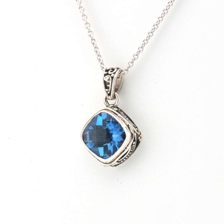 Silver necklace with a blue gemstone pendant on a white background