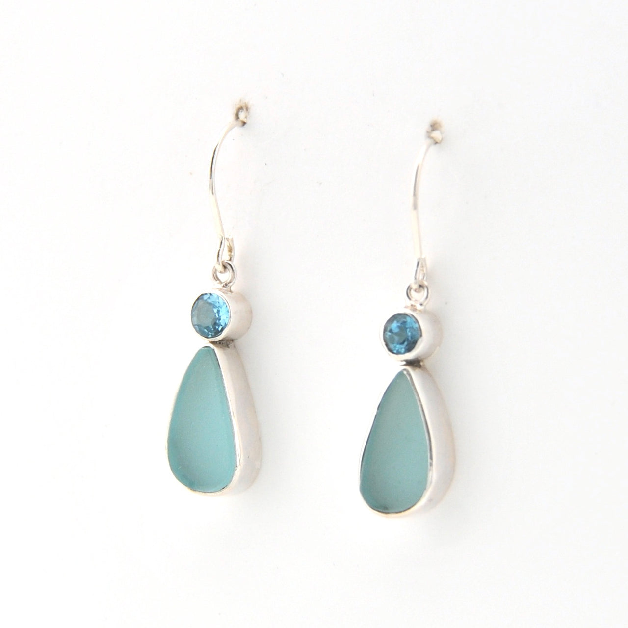 Pair of earrings with blue teardrop stones on a white background